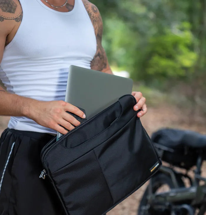 Man loading a laptop into the EscapeZone shoulder bag